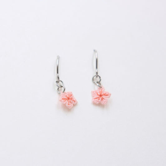 Pair of pink flower earrings on a white background