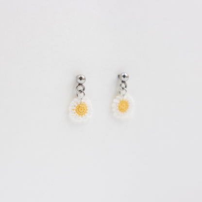 Pair of daisy-shaped earrings on a light gray background